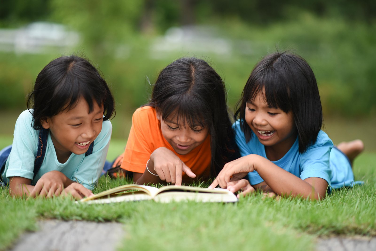 group-children-lying-reading-grass-field (1)