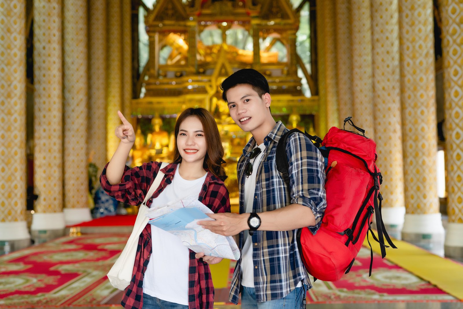 happy-asian-couple-tourist-backpackers-holding-paper-map-looking-direction-while-traveling-thai-temple-holidays-thailand-pretty-woman-pointing-target