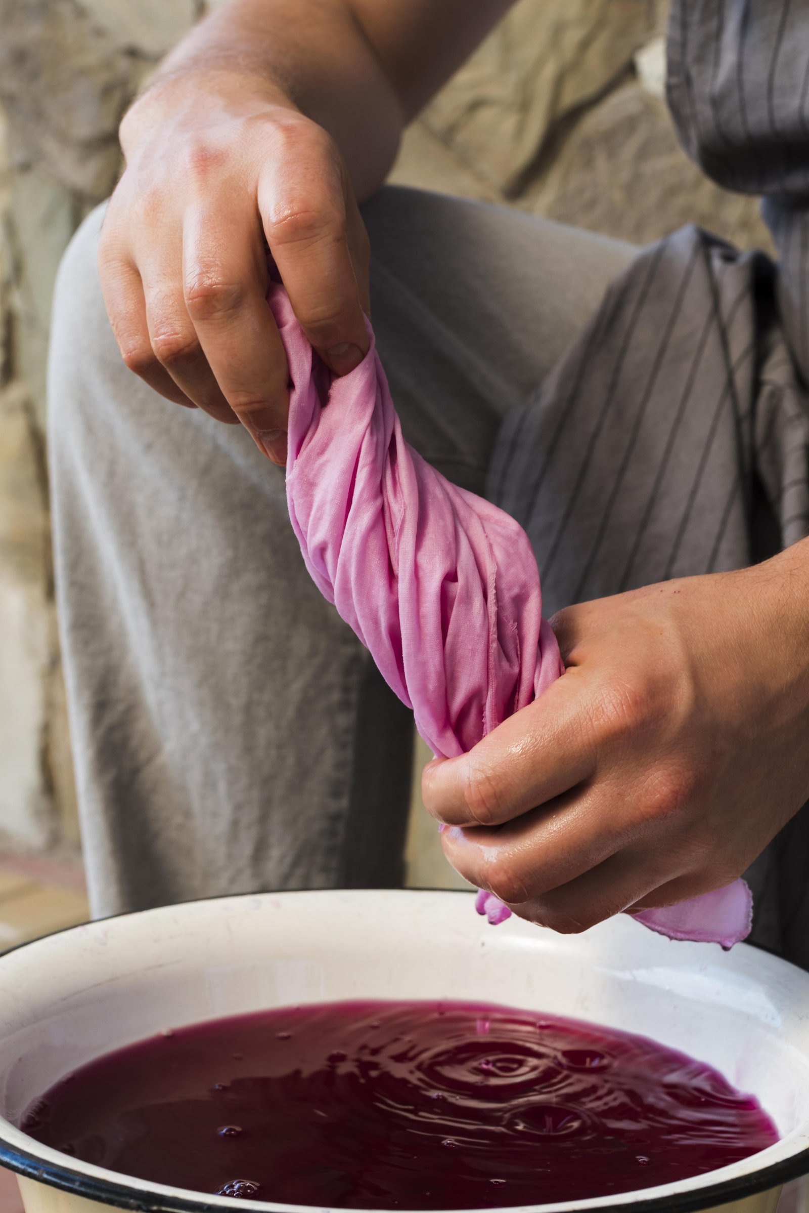 man-squeezing-cloth-from-pink-natural-pigment