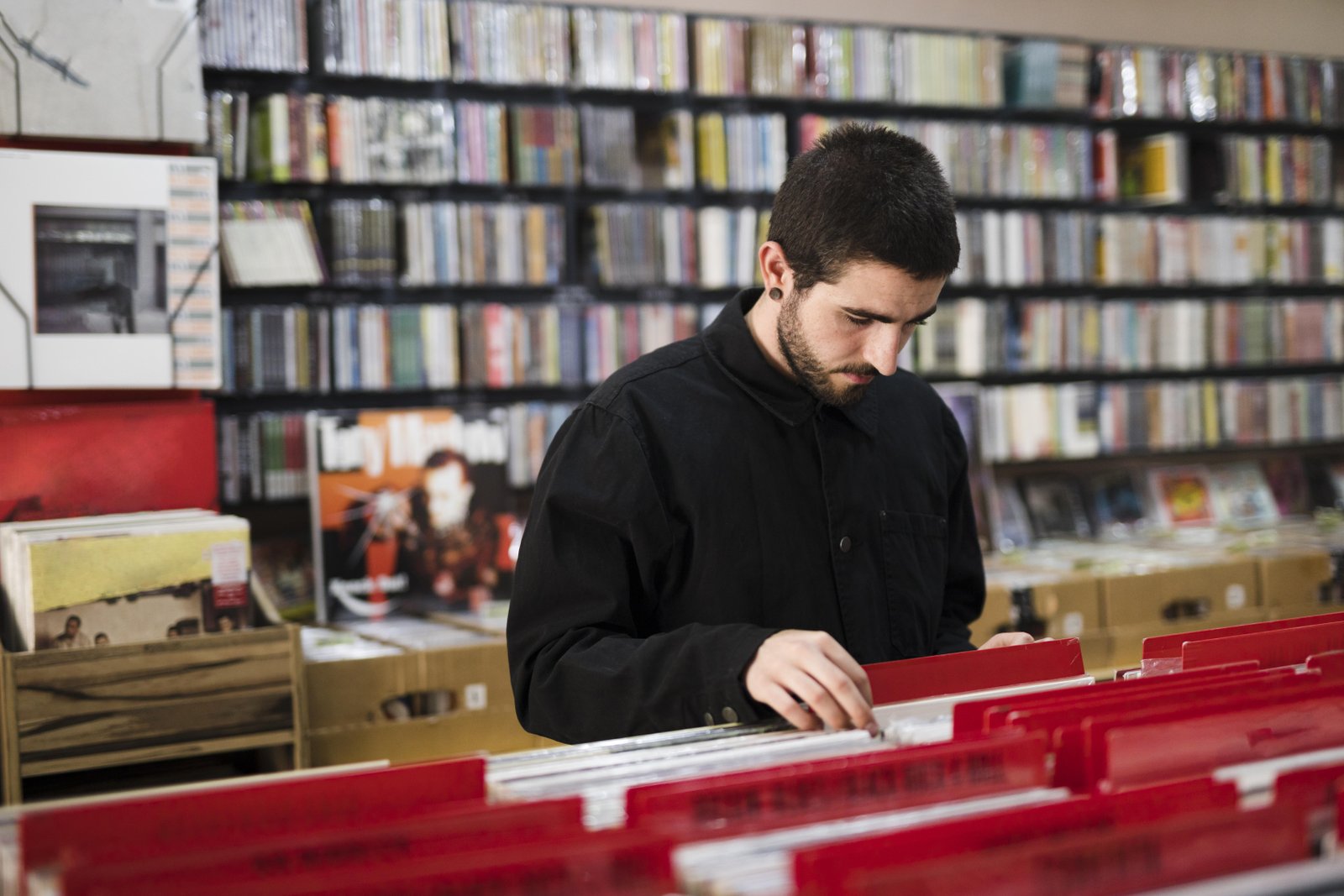 medium-shot-side-view-young-man-looking-vinyls-store