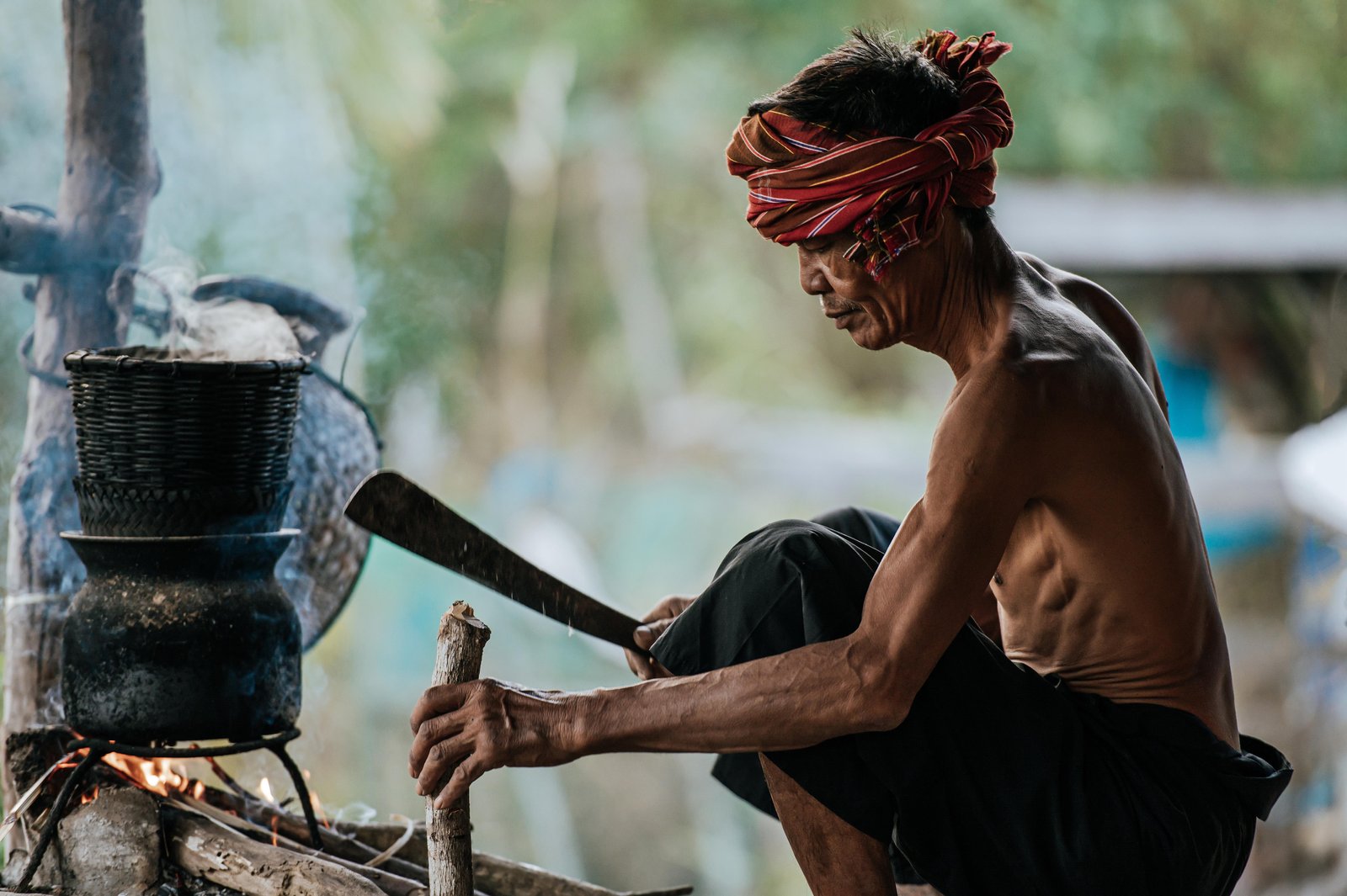 senior-man-shirtless-turban-loincloth-use-knife-cut-wood-make-firewood-steamed-sticky-rice-simple-life-rural-people-copy-space-rural-scene-countryside-thailand