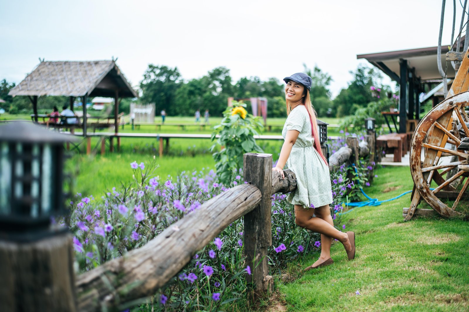 woman-happily-stand-flower-garden-wooden-railings